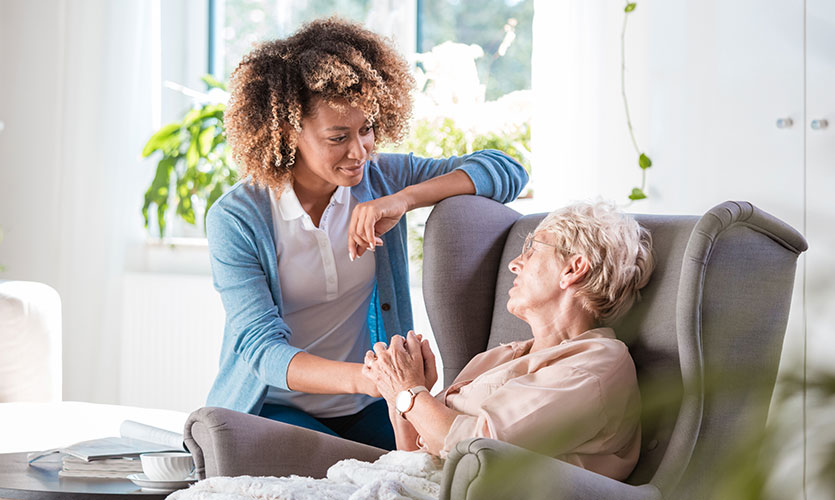 Elderly woman being comforted by a nurse