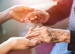 Person holding elderly hands