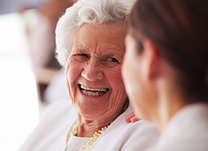 Elderly woman laughing with someone