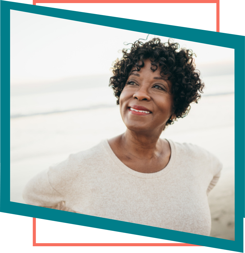 Elderly woman on a beach smiling.