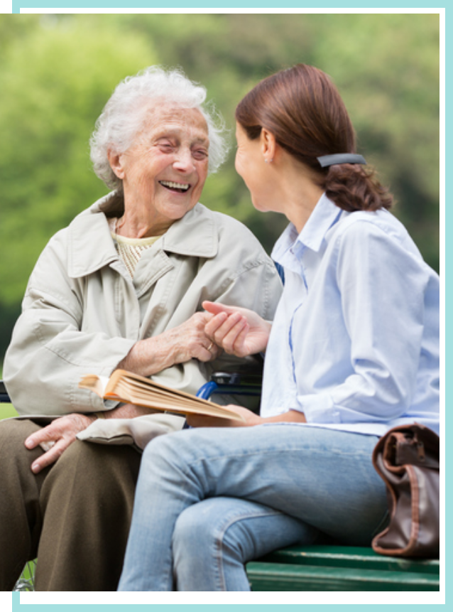 Elderly female patient laughing with visiting granddaughter