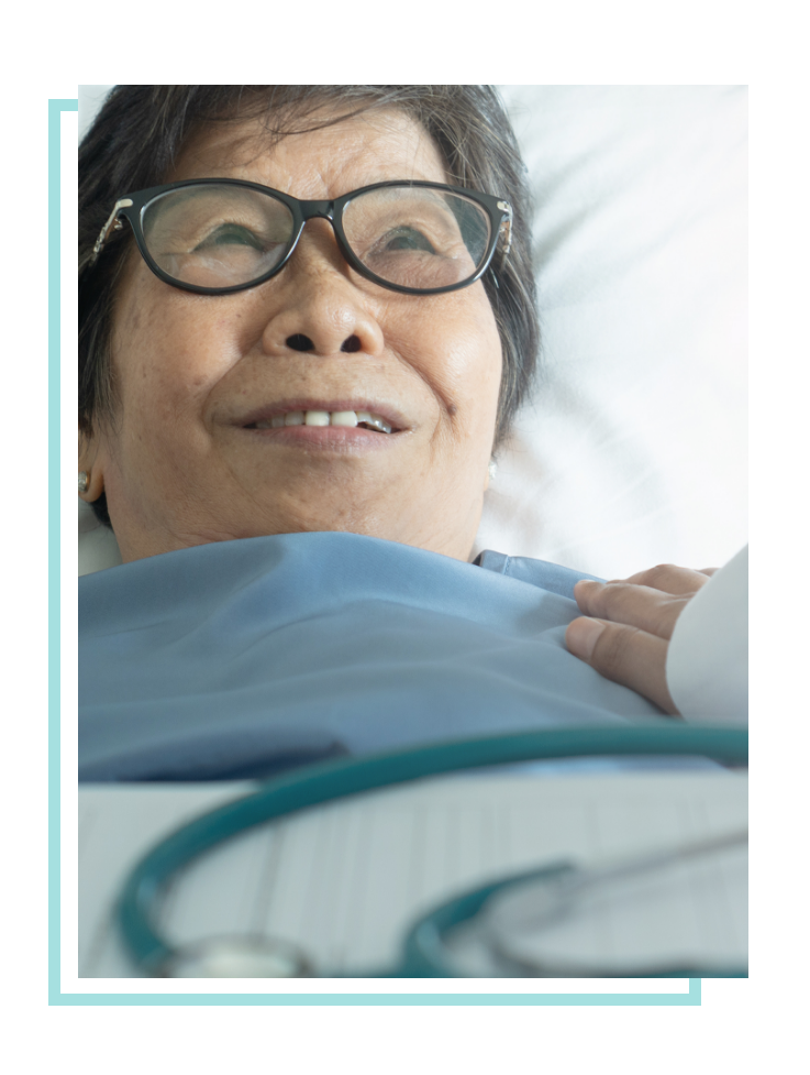 Woman wearing glasses lying down in bed