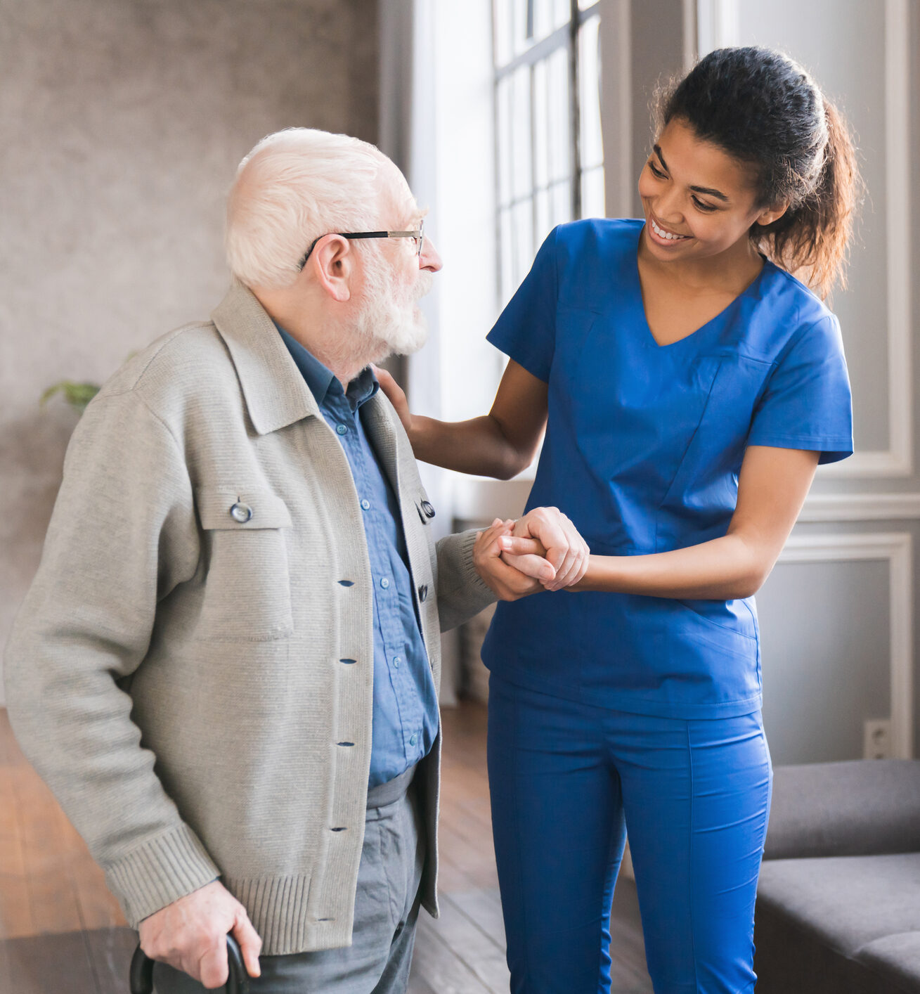 Female nurse assisting elderly man.