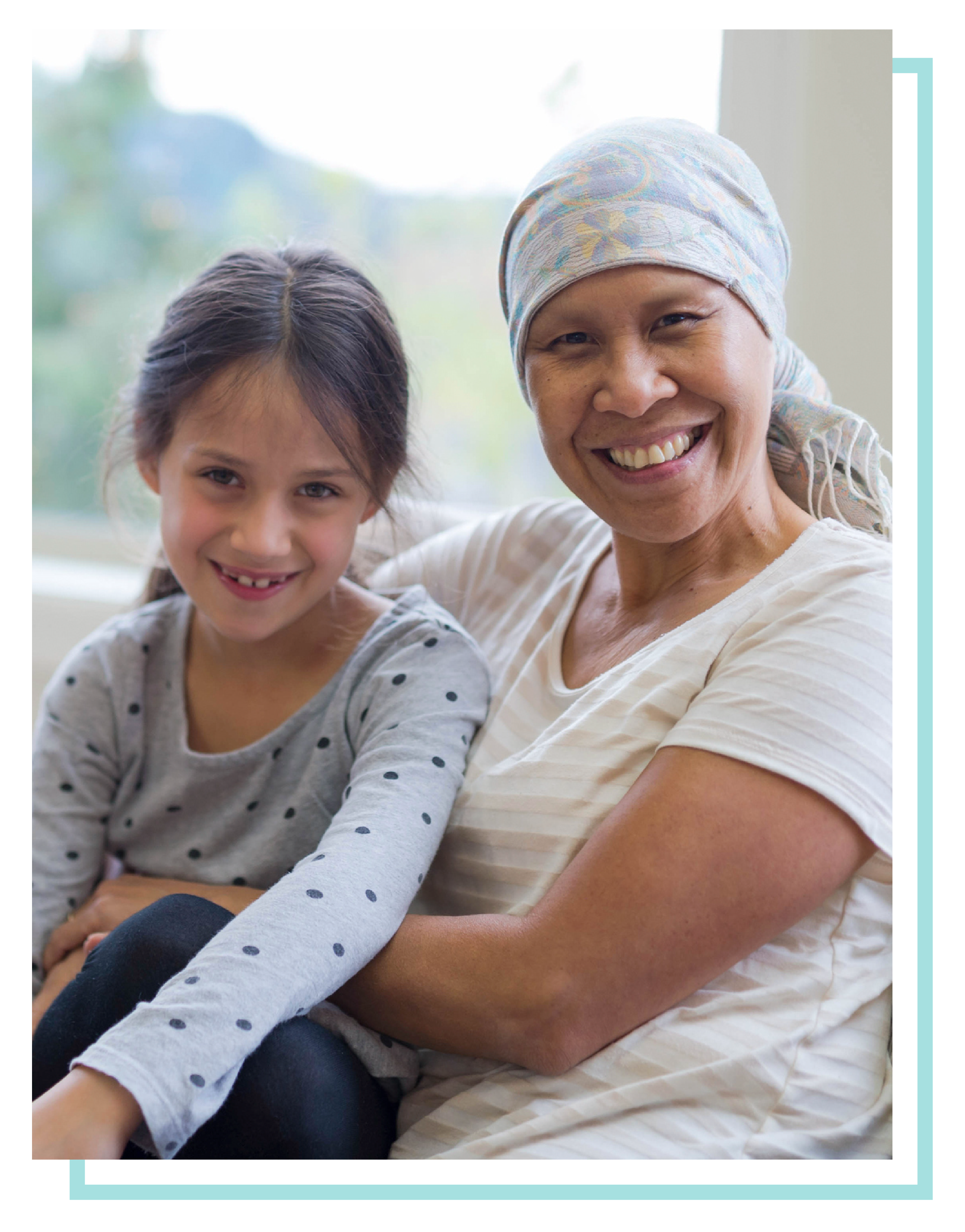 Female palliative care patient snuggling with granddaughter