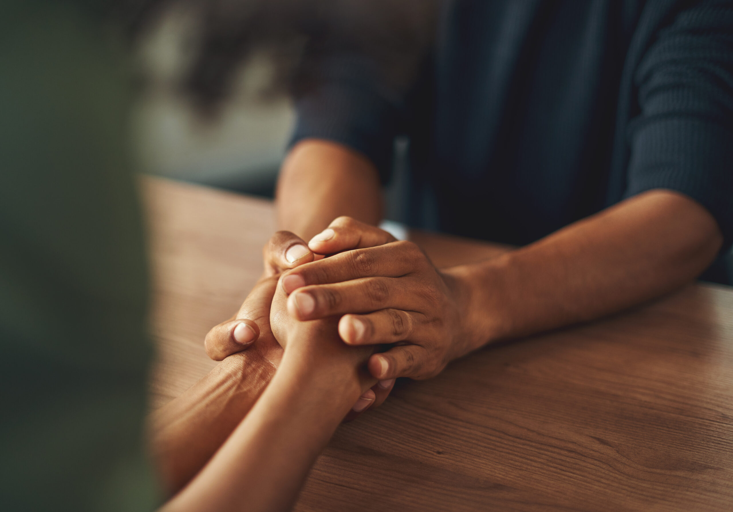 spiritual counselor comforting family member over the wooden table