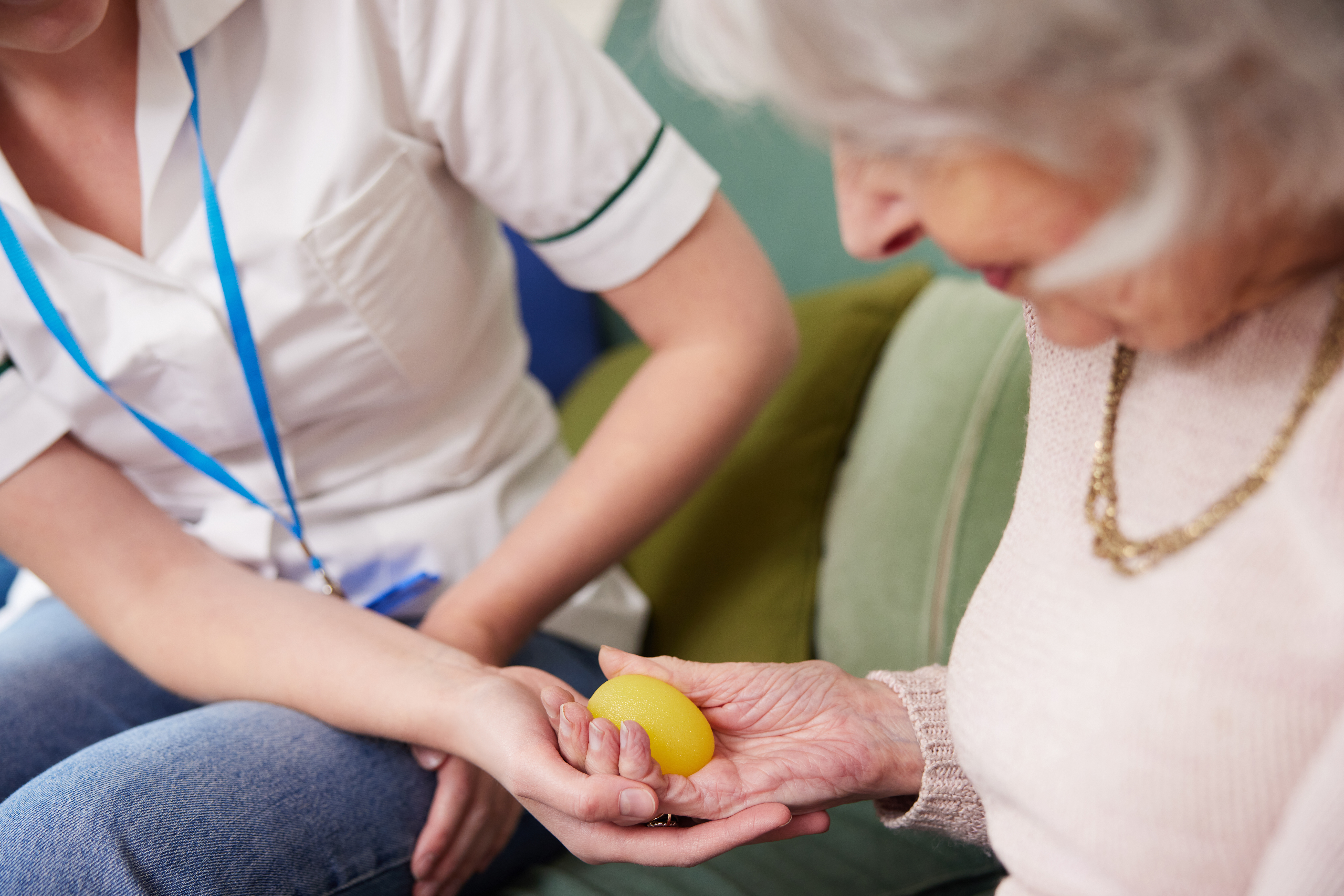 Occupational therapist works with senior woman on hand strength