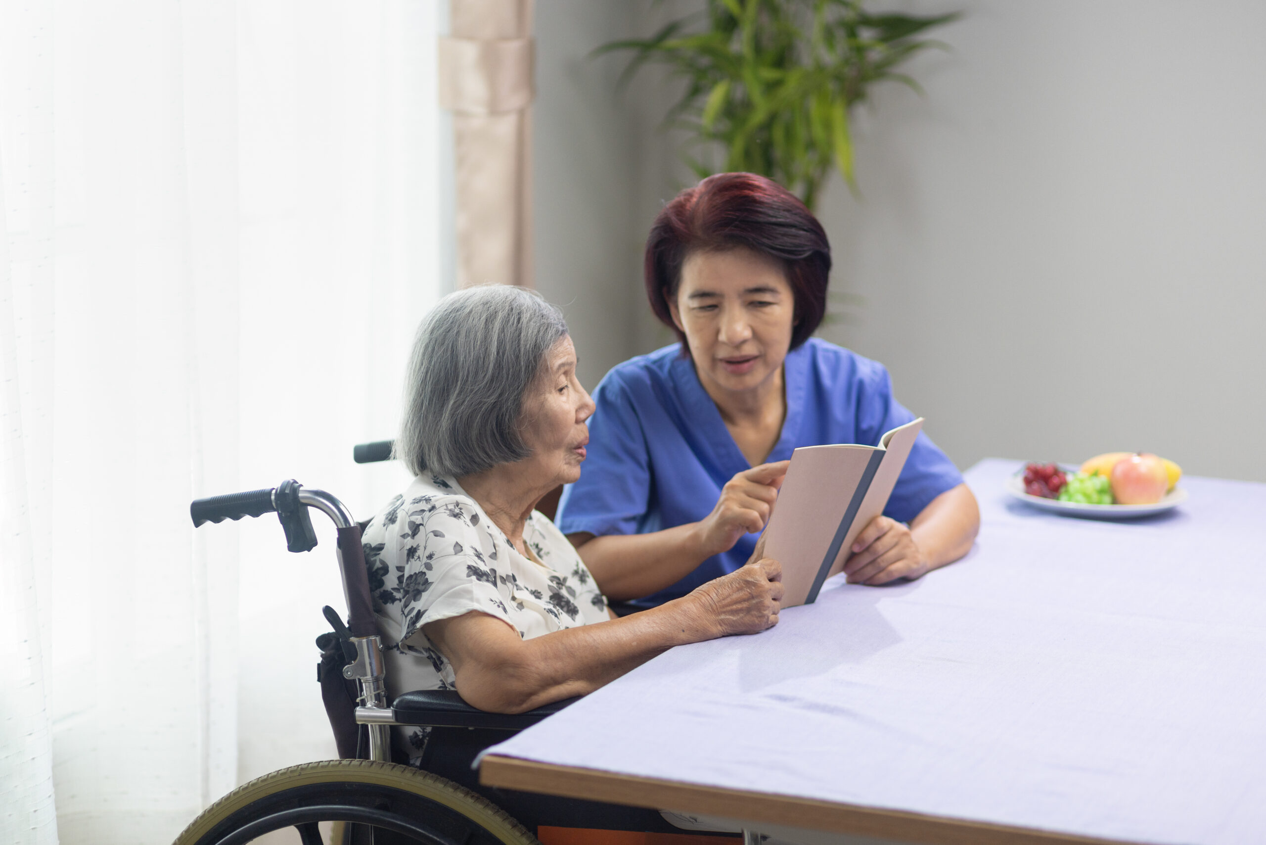 Elderly woman reading aloud a book for an at-home speech therapy session with a speech therapist