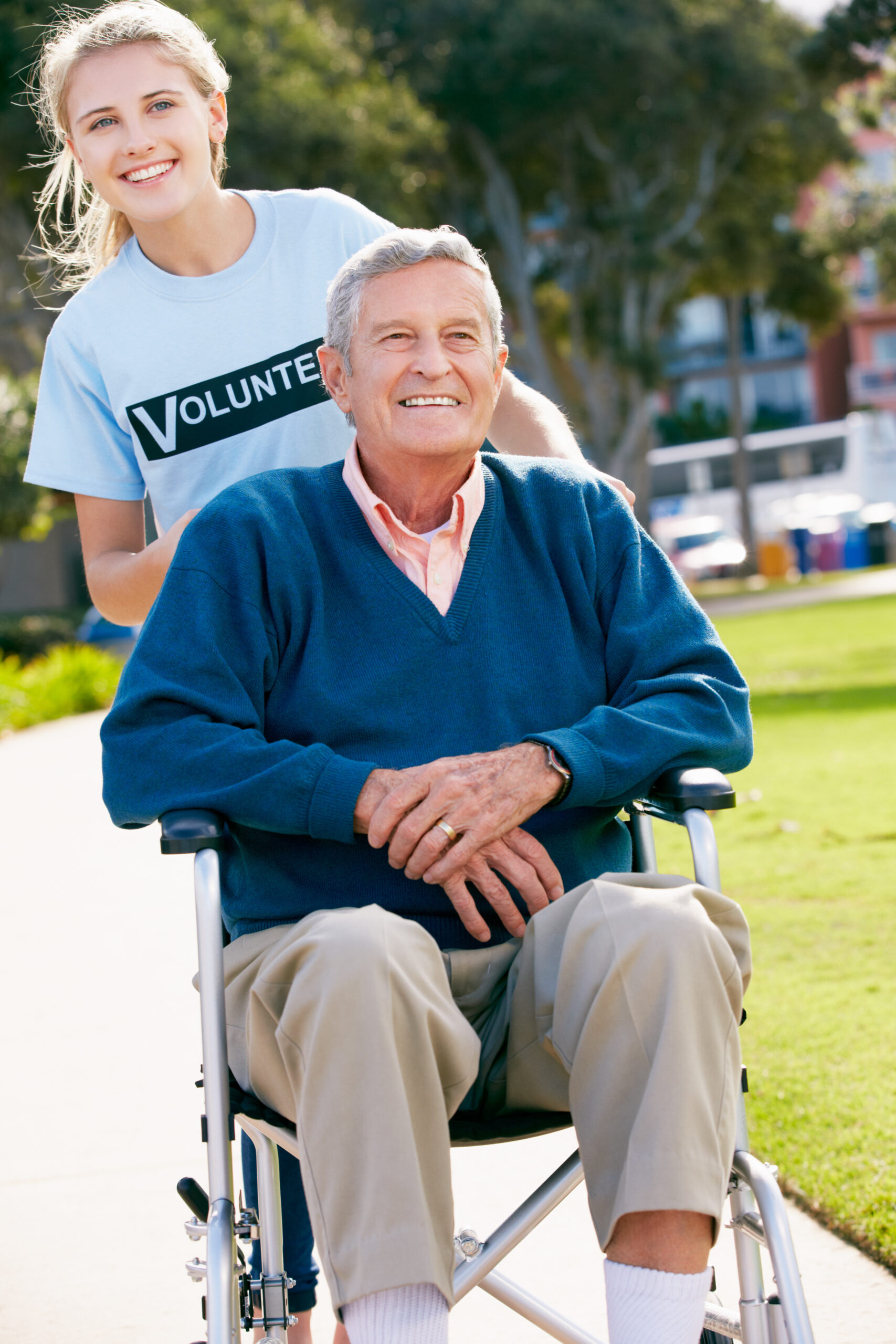 Female volunteer assisting elderly man.